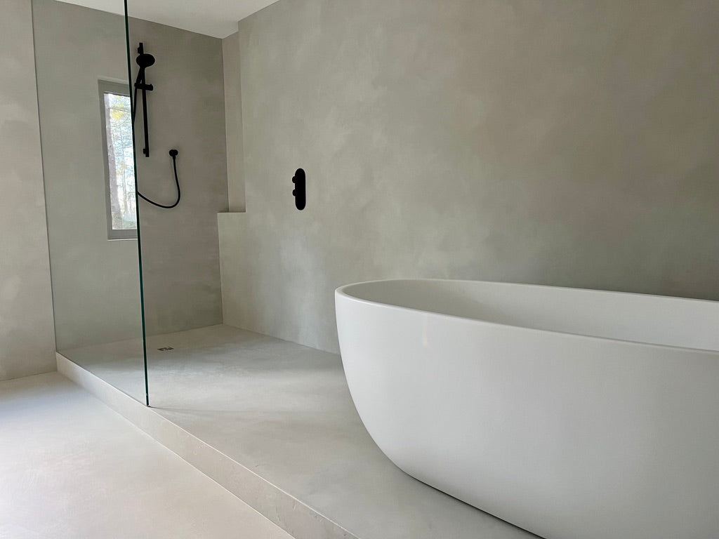 Cadoro DecoPast bathroom project with continuous walls and a freestanding bath