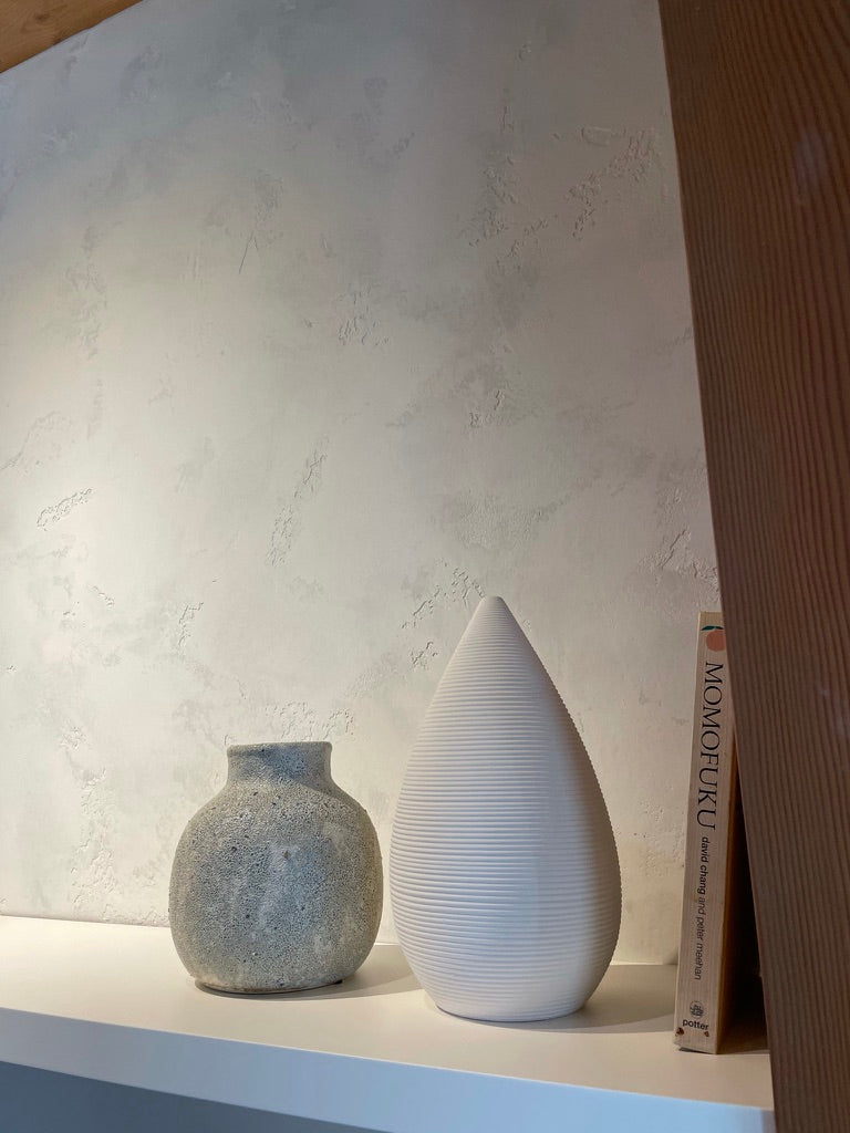 Matteo textured lime plaster wall behind ceramic vases on a shelf