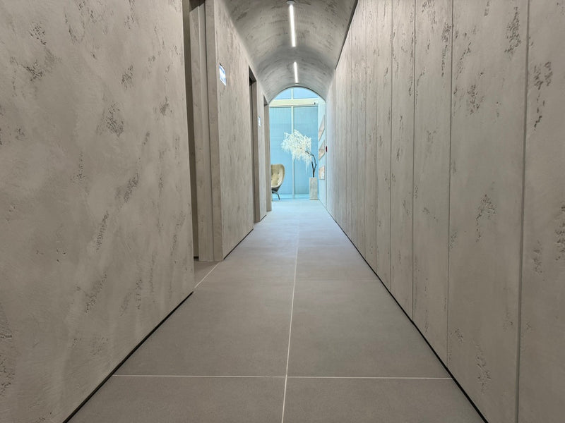 Travertino plaster walls and vaulted ceiling along a softly lit corridor